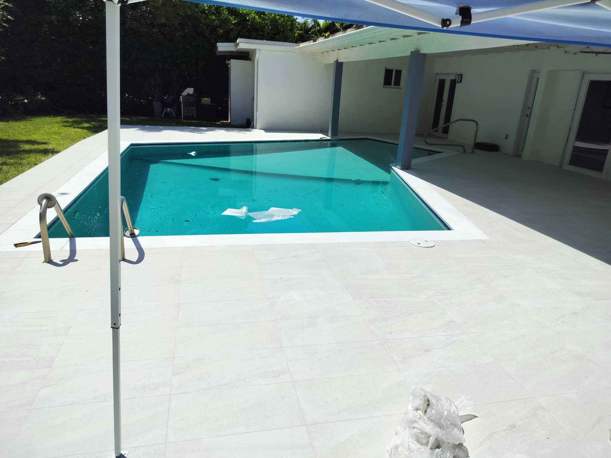 Backyard pool deck with large-format porcelain pavers