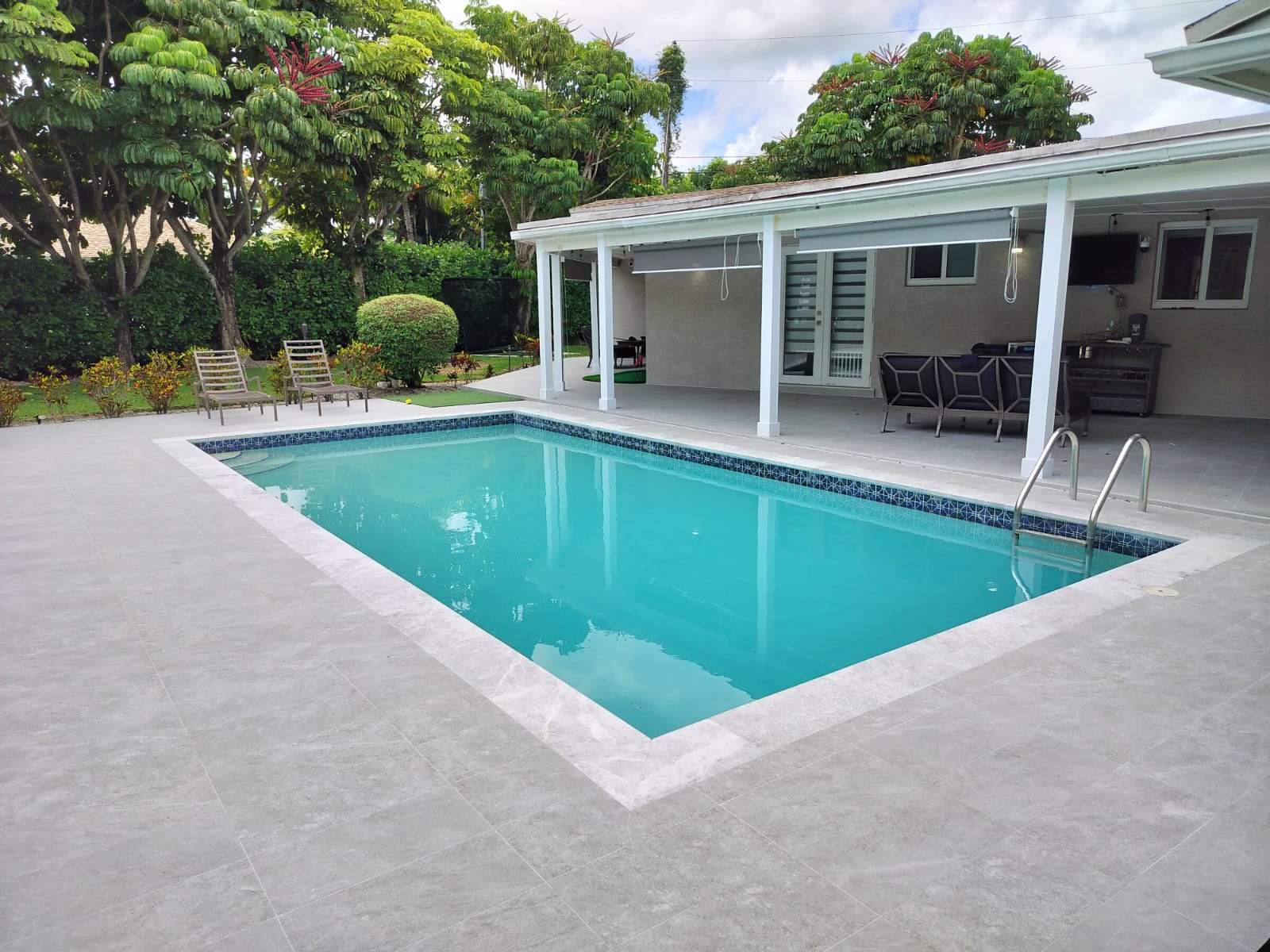Covered pool and patio with light grey porcelain tile